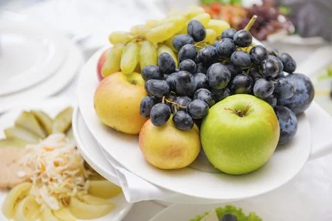 Plate of fruit on the table, apples, grapes Stock Photos