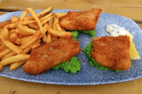 A plate full of Cod and crispy french fries Stock Photos