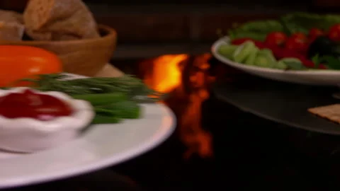 Plate with grilled sausages on table next to fire Stock Footage 120735254