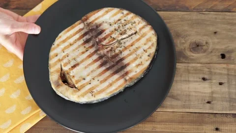 Plate with grilled tuna slice. Hand serving plate on wooden table. Horizontal Stock Footage 245226252
