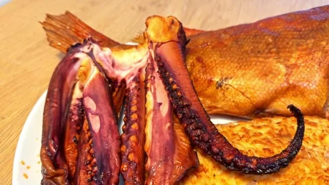 A Plate Holds Smoked Octopus, Fish, and a Large Piece of Baked Bread on a Stock Footage 333314799