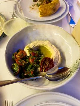Plate of hummus on table with white sheets, food in restaurant Stock-Fotos