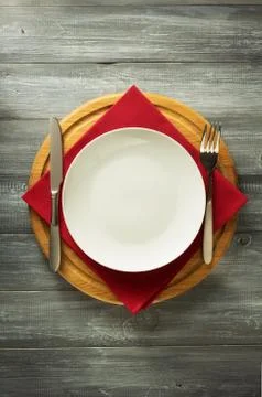 Plate, knife and fork on rustic background Stock Photos