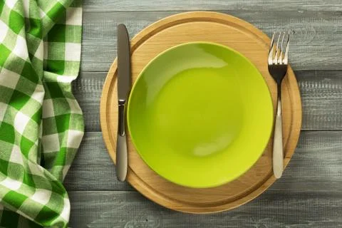 Plate, knife and fork on rustic background Stock Photos