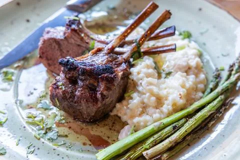 A plate of lamb chops and risotto with asparagus Stock Photos