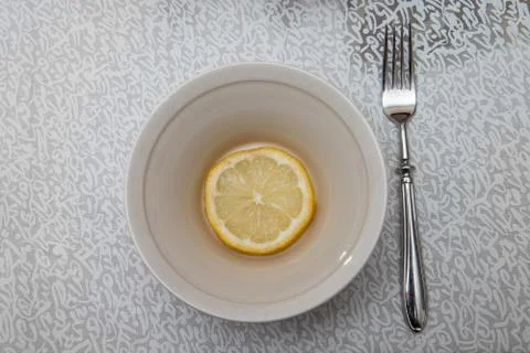 Plate with a lemon slice and a fork Foto stock