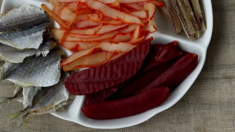 Plate with lots of beer snacks. Dried salted mackerel fish, cod fillets, squid Stock Footage 229763827