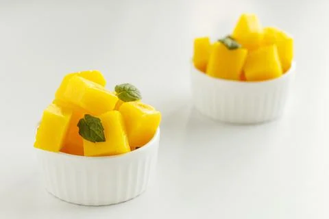 Plate with mango pieces on a white background. Stock Photos