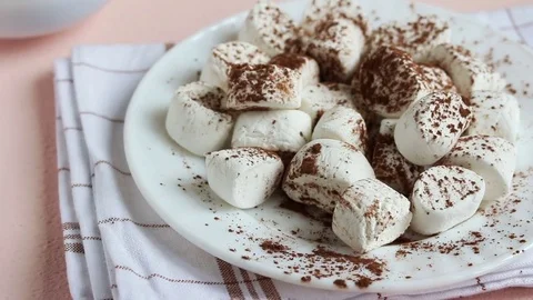 From plate with marshmallows with fork gets one piece Vídeo Stock 72610280
