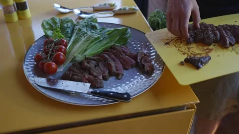 A plate of meat and vegetables is being prepared by a person Stock Footage 297871973