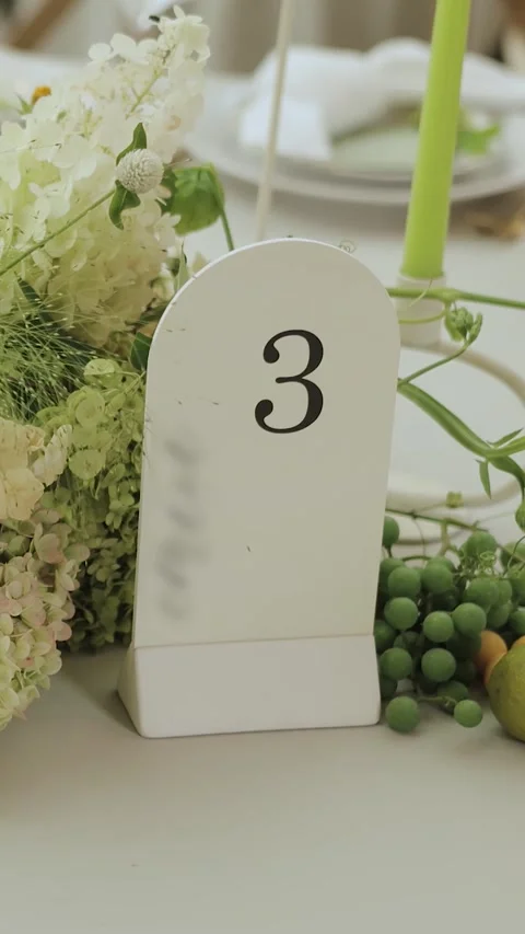 A plate with the number three on the table and a flower arrangement combined Stock Footage 306530045