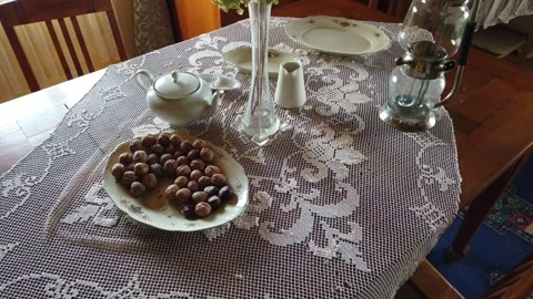 Plate with nuts, old kettle and a vase with flowers. Old Celtic village. Stock Footage 133802715