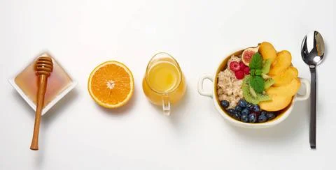 Plate with oatmeal and fruit, half a ripe orange and freshly squeezed juic... Stock Photos