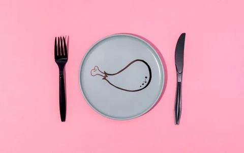 Plate with painted cartoon chicken leg and fork served on pink surface Stock Photos