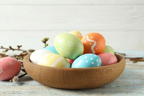 Plate with painted Easter eggs on table against wooden background 스톡 사진