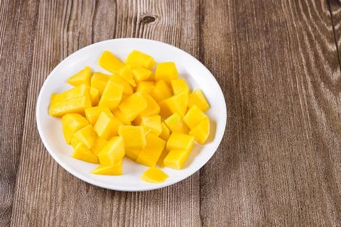 Plate with pieces of mango on the table, close-up Stock Photos