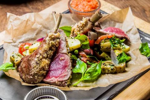 A plate of rack of lamb on a table Stock Photos