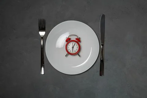 Plate with red alarm clock Fotos Stock