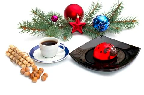 Plate with red cake, coffee and Christmas tree decorations on a coniferous br Stock Photos