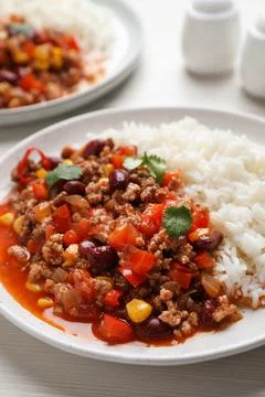 Plate of rice with chili con carne on white wooden table Stock Photos