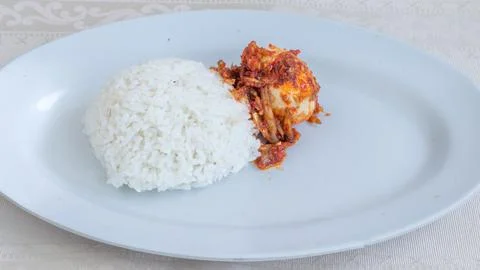 A plate of rice with egg balado sauce, egg sauce, anchovies and tofu. Serve.. Stock Photos