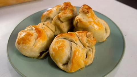 Plate rotating with four freshly baked wrapped in dough pears with nuts. Stock Footage 313047428