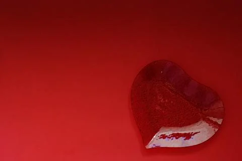 A plate in the shape of a heart on red background Stock Photos