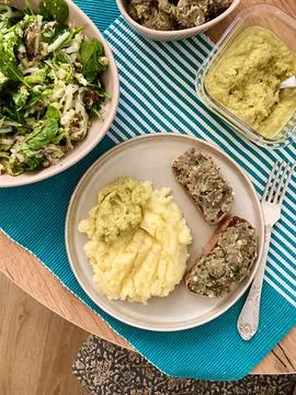 A plate shows a serving of boiled potatoes with hummus, a gluten free bread s Stock Photos