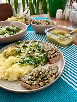 A plate shows a serving of boiled potatoes with hummus, a gluten free bread s Stock Photos