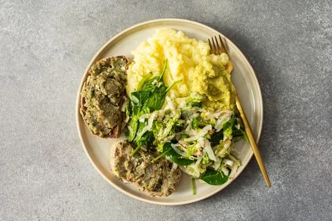 A plate shows a serving of boiled potatoes with hummus, a gluten free bread.. Stock Photos