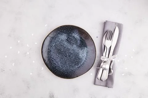 Plate, silverware, decor on a light gray background. Stock Photos