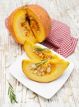 Plate with sliced pumpkins on kitchen table Stock Photos