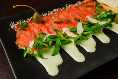 A plate with sliced red fish, bread and greens Stock Photos