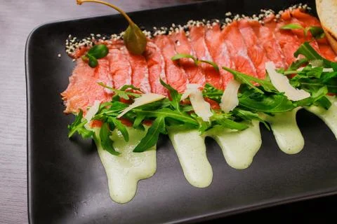 A plate with sliced red fish, bread and greens Stock Photos