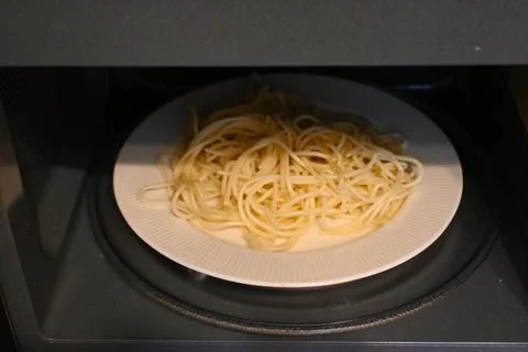 Plate of spaghetti inside a microwave Stock Photos