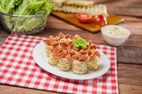Plate of spaghetti spring rolls with fried pork and herbs on the table in res Stock Photos