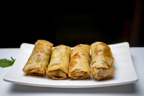 A plate of spring rolls on a white table Stock Photos