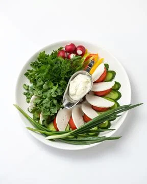 Plate with spring salad. Assorted fresh herbs and vegetables with soft cheese Stock Photos