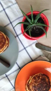 Plate with stack of pancakes and cactus in red pot, selective focus Stock Photos