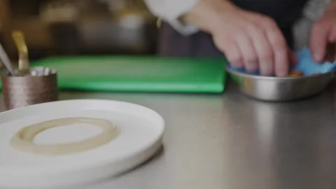 A plate is on a table with a green cutting board Stock Footage 306577116