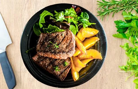 Plate on the table with steak and chips Stock Photos