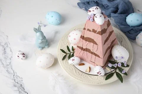 Plate with tasty curd Easter cake, eggs, ceramic bunny, gypsophila flowers an Stock Photos