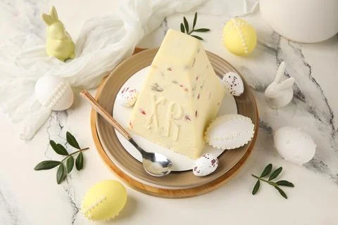 Plate with tasty curd Easter cake, eggs and leaves on marble background Stock Photos