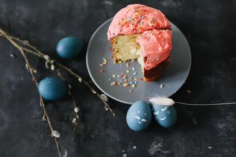 Plate with tasty Easter cake, eggs and willow branches on dark background Foto stock