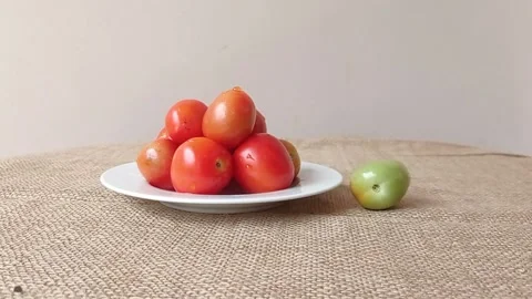 A plate of tomatoes and a rolling tomato Stock Footage 149957682