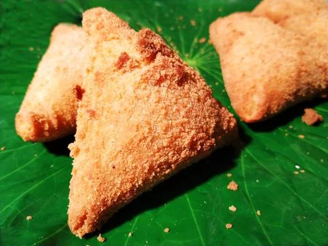 A plate of triangular pastries on a green leaf. Foto stock