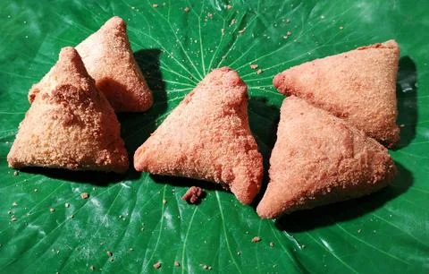 A plate of triangular pastries on a green leaf. Foto stock