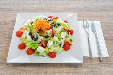 A plate with a walnut salad on the table overlooking the restaurant. Stock Photos