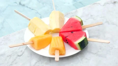 A plate of watermelon, pineapple, and melon skew on plate near swimming pool 動画素材 237881234