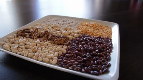 Plate on which dry red beans and yellow peas and various nuts. Stock Footage 114740065